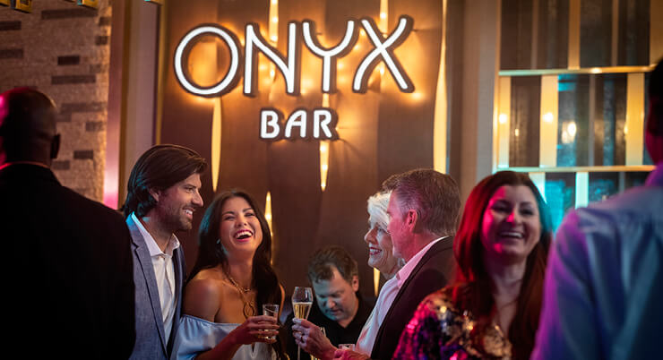 People laughing and enjoying drinks at the ONYX Bar