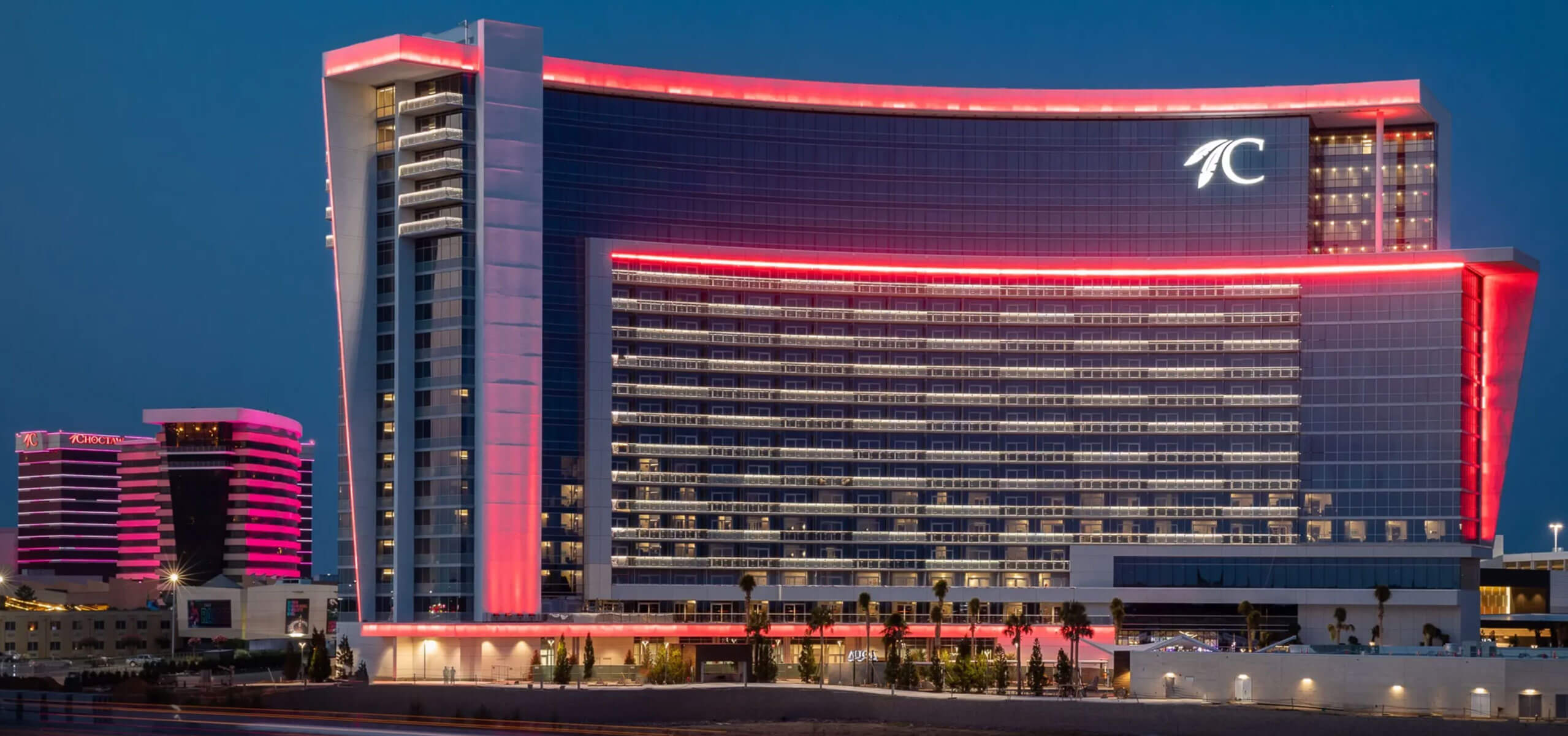 Choctaw Durant hotel tower at dusk, outlined in pink lighting.