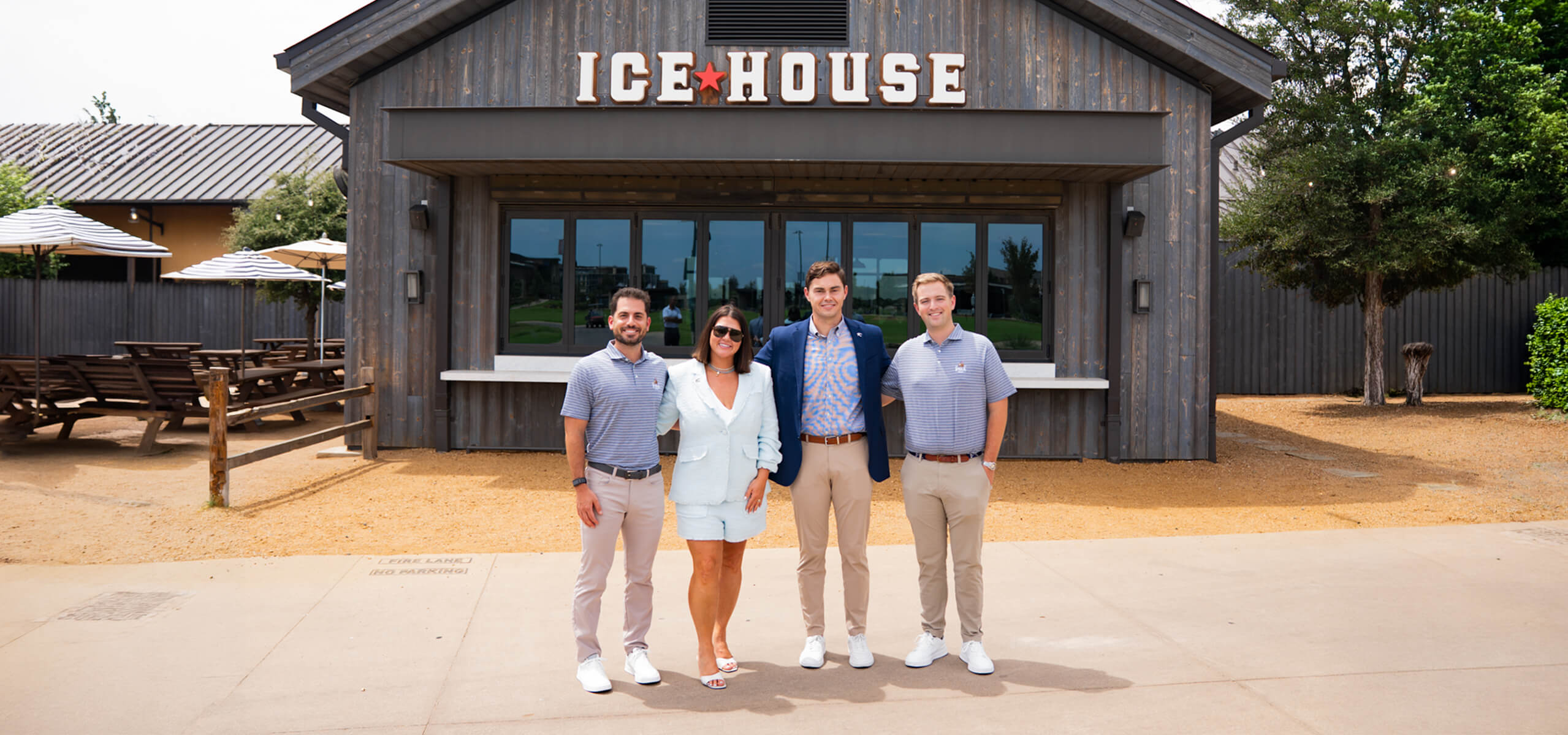 Four people pose outside the Ice House at PGA Frisco.